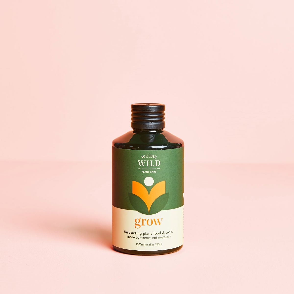 bottle with we the wild grow plant food and tonic with pink background