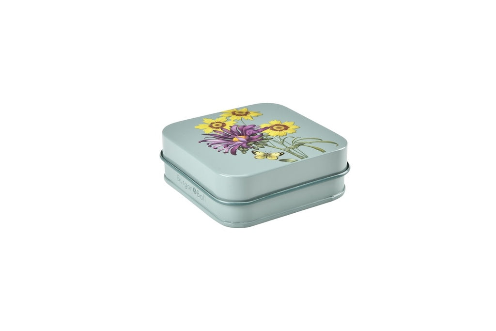 Small square tin with floral design on a white background