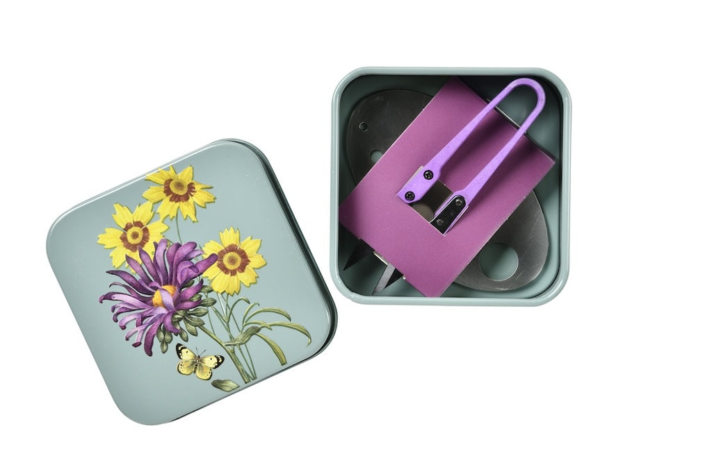 Pink tool in a tin box with floral design on a white background