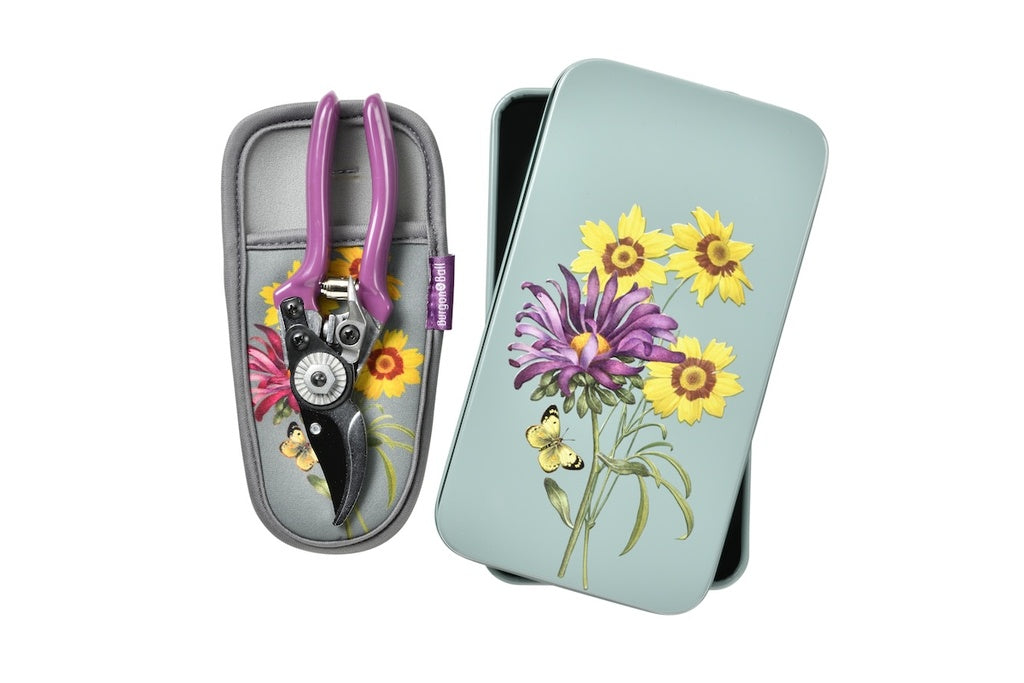 Tin case with floral design and garden shears on a white background