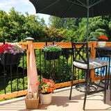 Outdoor patio with table, chairs, and hanging planters on a wooden deck.