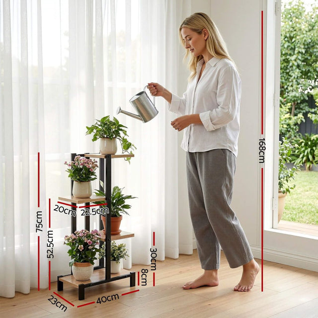 Woman watering plants on a black metal plant stand with dimensions indicated.
