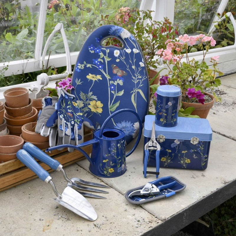 Gardening tools and accessories with floral design on a table outdoors.