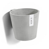 Gray recycled plastic pot on wall with label on white background