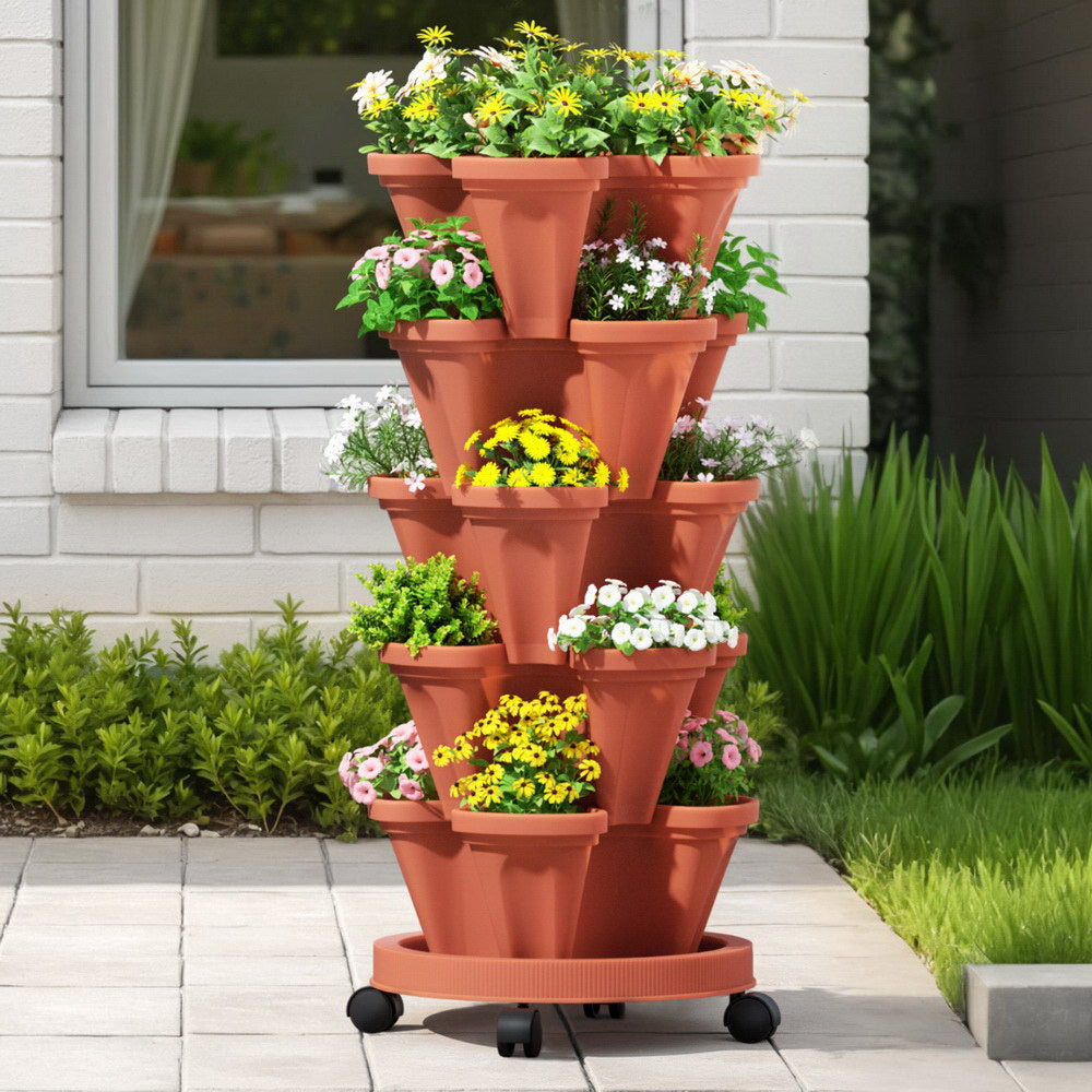Terracotta tiered vertical plant stand with flowers in a garden setting