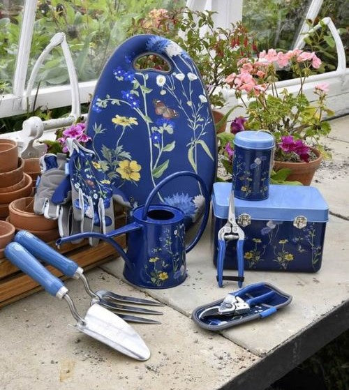 Gardening tools with floral design on a table in a garden setting