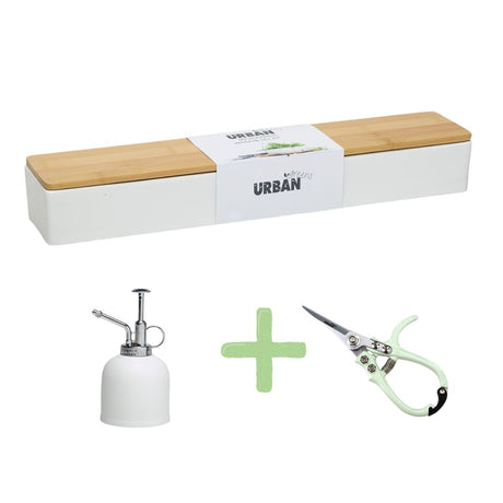 Gardening tools including a plant mister, snips, and a planter with microgreens on a white background.