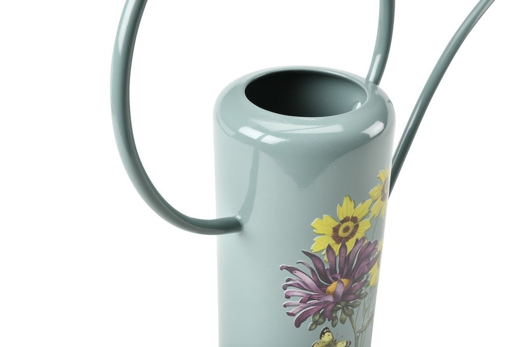 Closeup of Light blue watering can with floral design on a white background