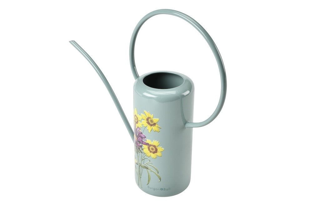 Light blue watering can with floral design on a white background